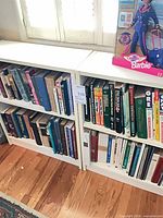 Front view of two white bookcases filled with books