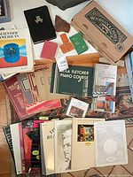 Overall lot showing books, sheet music stack and boxed Woodstock Chimes