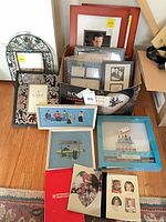 Overview of all frames, needleworks, shadowbox and photo album on floor