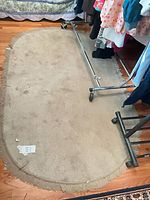 Full view of oval beige rug on hardwood floor showing overall size and condition