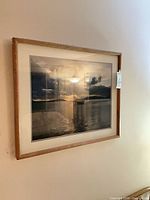 Larger framed photographic print showing sailboat on water at sunset