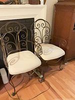 Two wrought iron armchairs side by side
