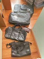 Four leather items arranged on floor
