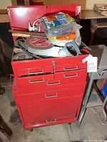 Front view of red rolling tool chest with tools on top