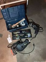 Lot overview showing reciprocating saw, toolbox with tools, and other items