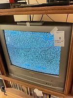 Front view of powered-on CRT TV showing static