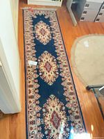 Full length view of navy Persian-style runner rug on hardwood floor