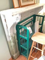 Full view of mantel surround leaning against wall with visible turned pilaster and corbel details