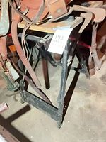 Western saddle on black metal stand