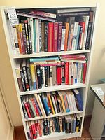 Full frontal view of white bookshelf filled with books