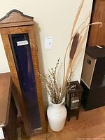 Full view of cabinet, vase with stems, lantern together