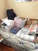 Overall view of daybed frame, mattress, boxed and bagged bedding on top