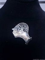 Full view of silver lady silhouette brooch on display bust