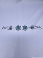 front view of full bracelet showing green cabochons and wire frame