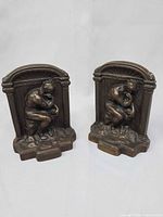 Front view of both cast iron The Thinker bookends