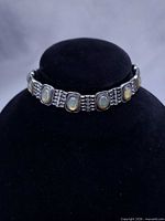 Front view of choker on display form showing cabochon and link pattern