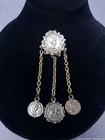 Full view of brooch showing three coin drops