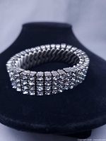 Full view of bracelet on display stand showing five rows of rhinestones and stretch design