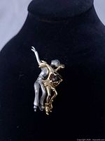 Front view of brooch showing two-tone figure skaters