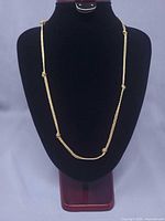 Full view of double rope knot necklace on display bust