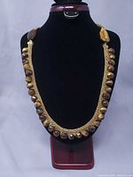 Full view of woven cashmere necklace with tiger's eye beads displayed on bust