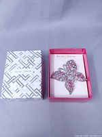 Brooch in open Jaclyn Smith box beside lid