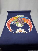 Full view of indigo tapestry with colourful bird motif