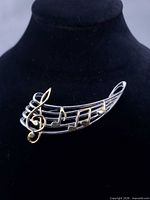 Front view showing silver staff and gold notes