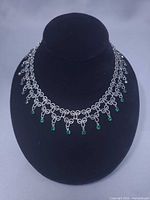 Full view of necklace on display bust showing design and dangling rhinestones