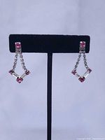 Front view of both earrings on stand