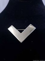 front view of V-shaped pin on display bust