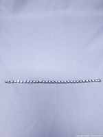 Full view of bracelet laid flat showing length and rhinestone row