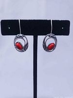 Front view of both earrings on display stand