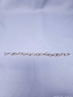 Full view of gold-coloured wire link bracelet laid flat