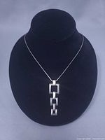 Full view of necklace on display bust showing chain and pendant