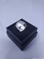 Front view of wide hammered sterling band on box