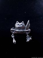 Front view of sterling silver cat brooch with dangling charms