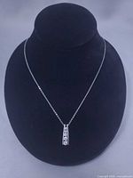 Full view of necklace on display bust showing pendant and chain