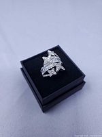 Ring set on presentation box, angled view showing floral rhinestone design