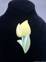 Front view of yellow tulip brooch on display stand