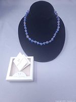 Necklace on display bust with box and card