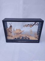 Front view of complete rectangular glass diorama with carved pavilion and bridge