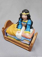 Front angled view of assembled figurine showing princess on mattresses in bed
