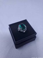 Ring front view showing green stone and heart motif