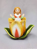 Thumbelina figurine seated in tulip base front view
