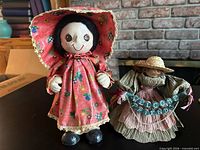 Front view of both dolls showing clothing, banner, and overall appearance