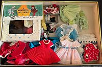 Overview of box showing all Betsy McCall doll clothes, hats, shoes and accessories