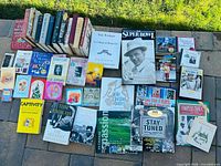 Top-down view showing all books, DVD case and CDs on patio stones