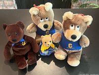 Group shot of four Cal plush bears showing front details and colors