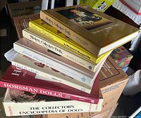 Stack of seven doll reference books showing titles and bindings